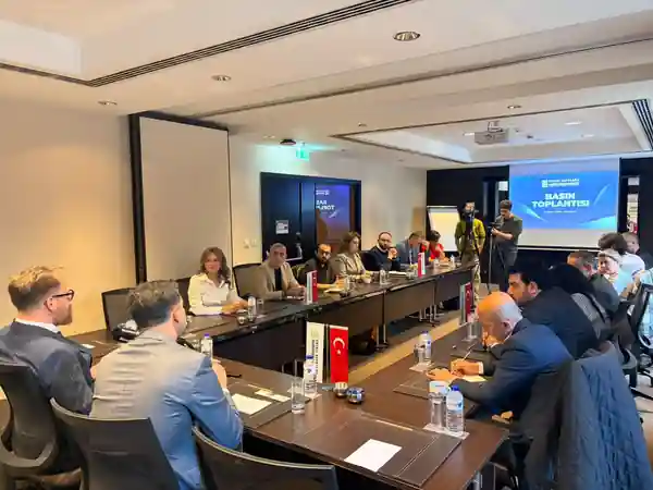 Basın toplantısı salonu, perdede EDEDER Basın Toplantısı yazısı ve kameralar